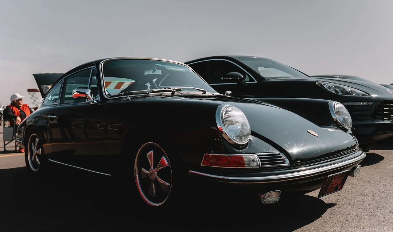 Vintage dark-green Porsche 911 front three-quarter in low sun
