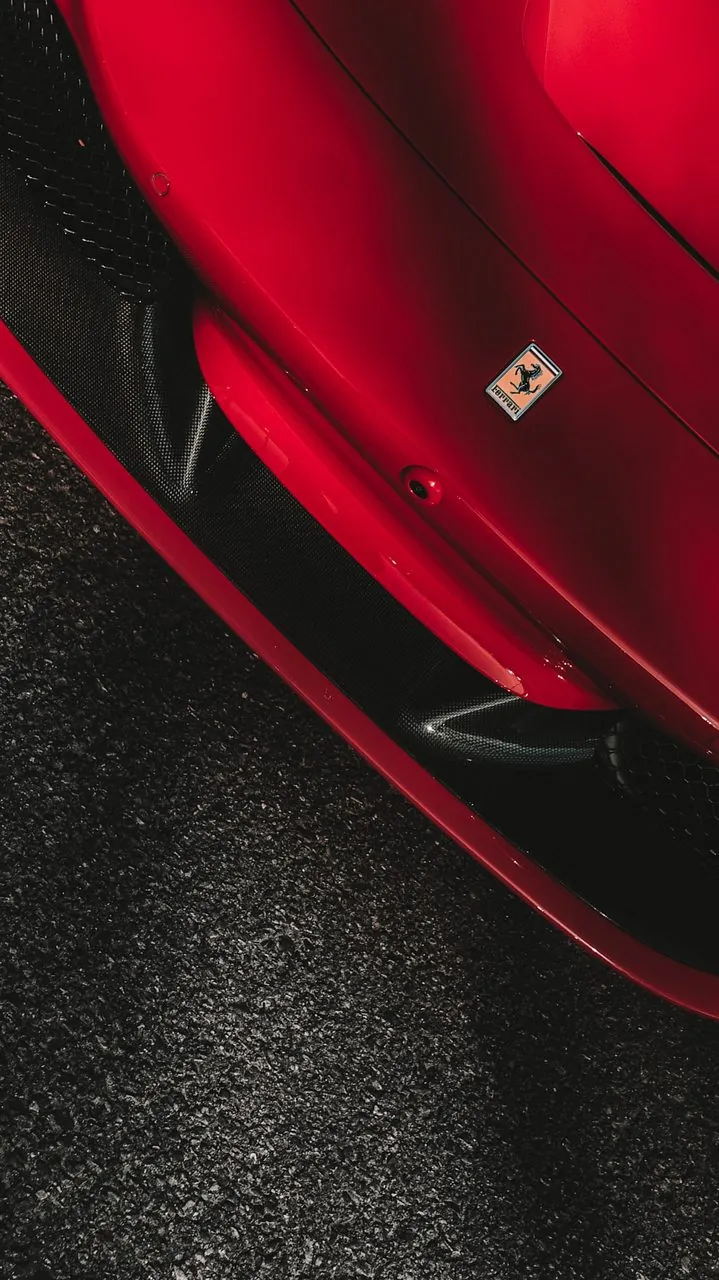 Overhead detail of a red Ferrari front splitter and badge