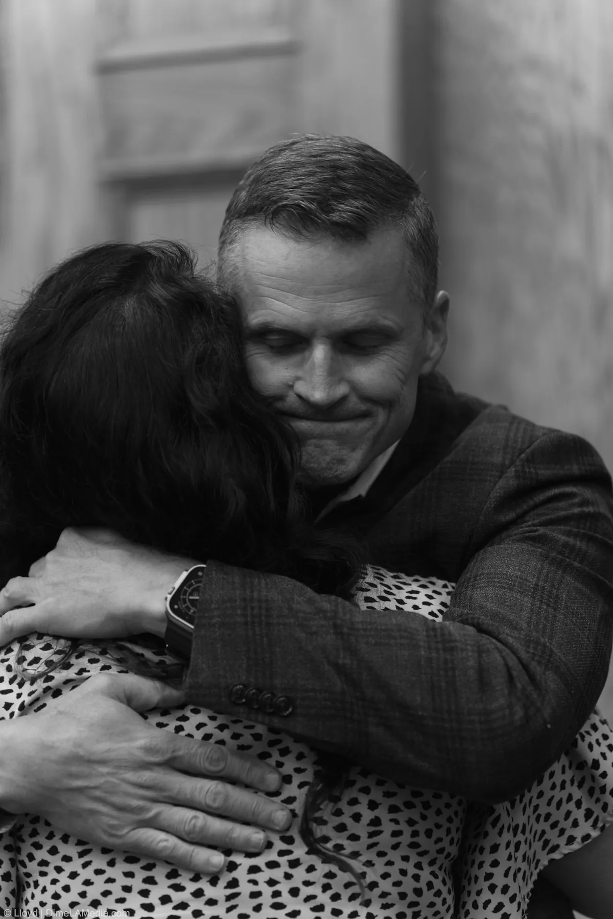 Black and white frame of Paul TenHaken embracing a guest before the inauguration ceremony