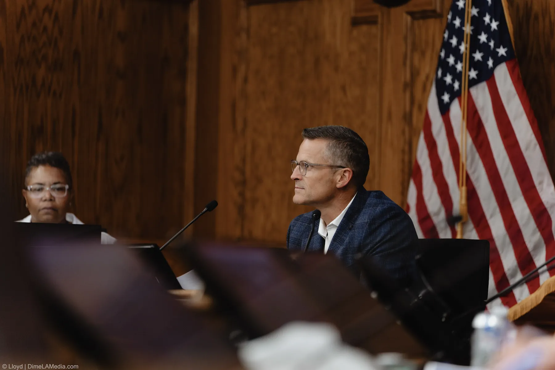 Paul TenHaken seated at the dais beside the American flag during his final session as mayor