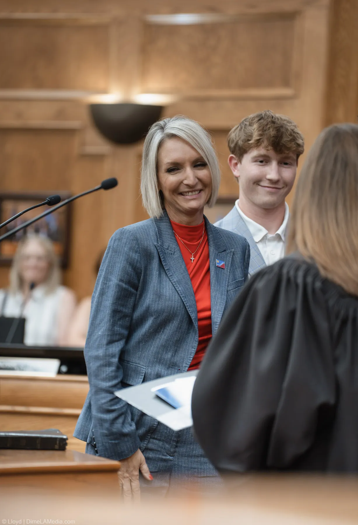 Christine Erickson smiles with her son behind her as the ceremony concludes