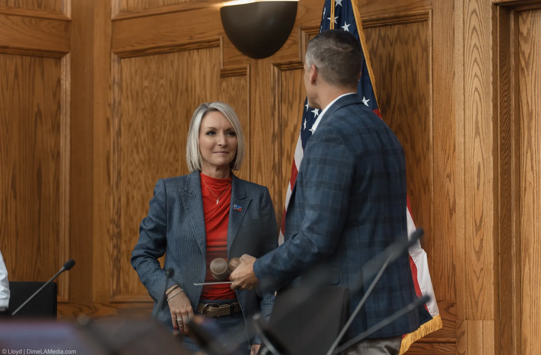 Paul TenHaken hands the gavel to Christine Erickson in front of the American flag