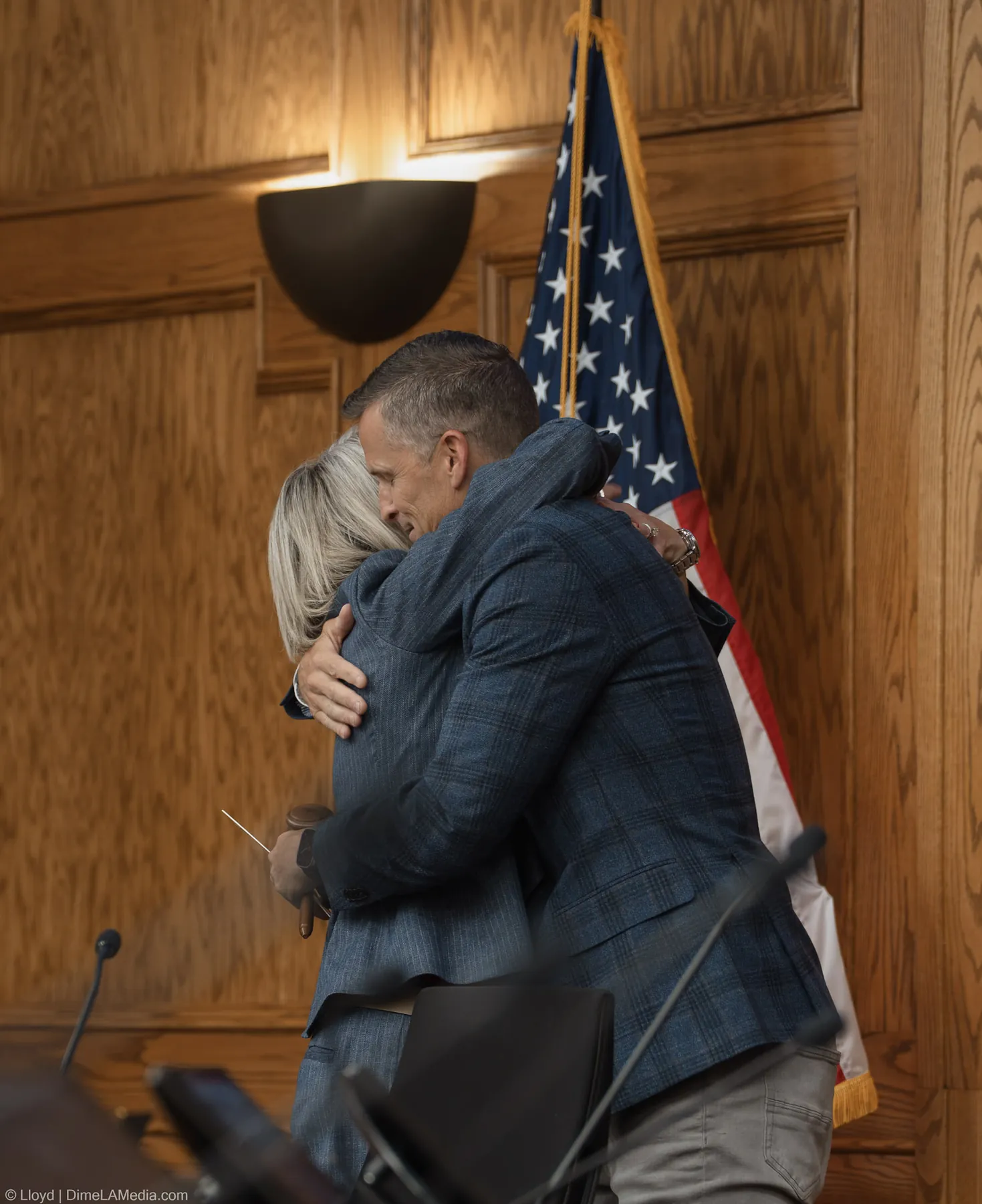 Paul TenHaken and Christine Erickson embrace after the gavel handoff, the gavel in her hand