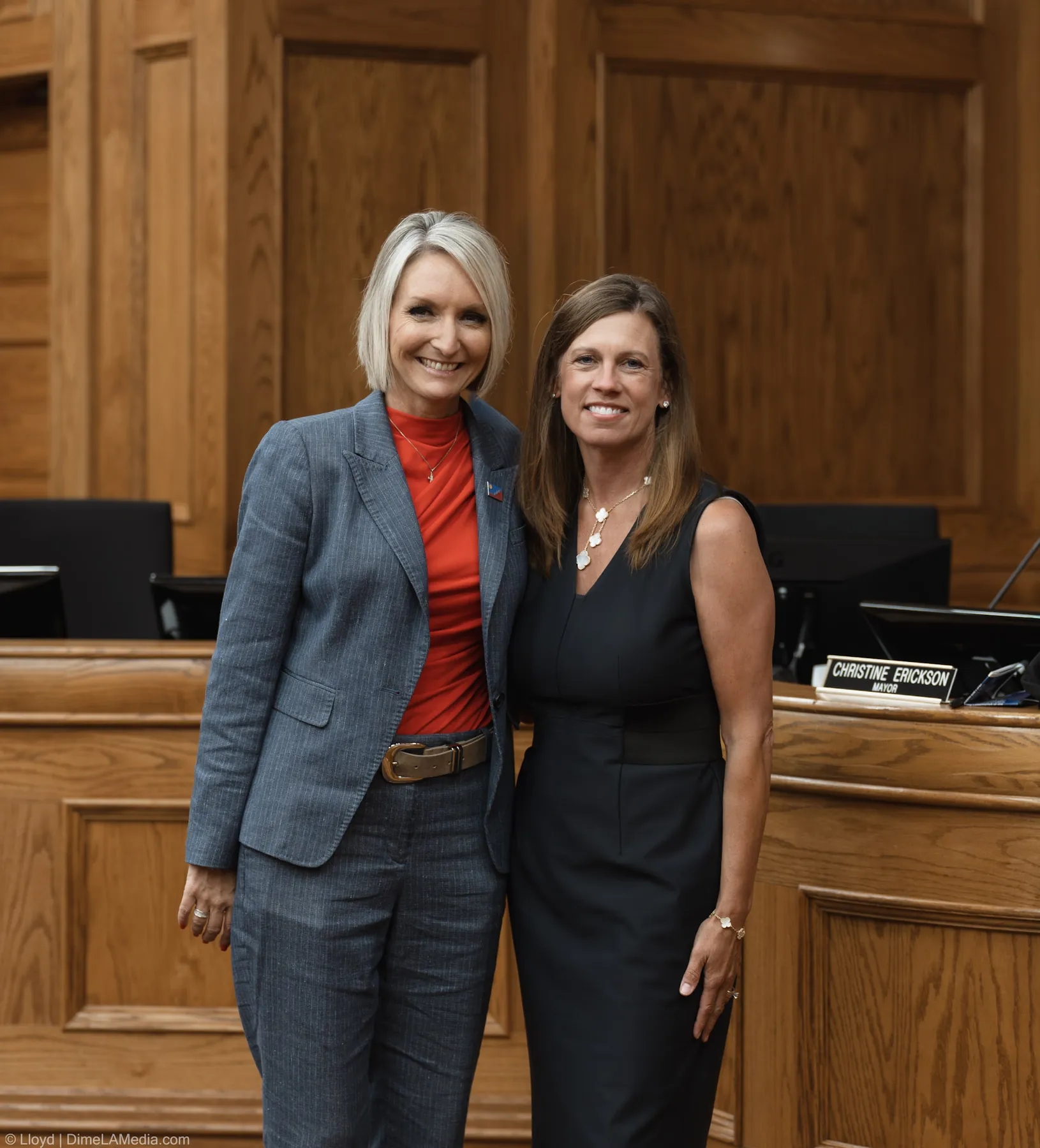 Mayor Christine Erickson poses with a guest beside her new mayor nameplate at the dais