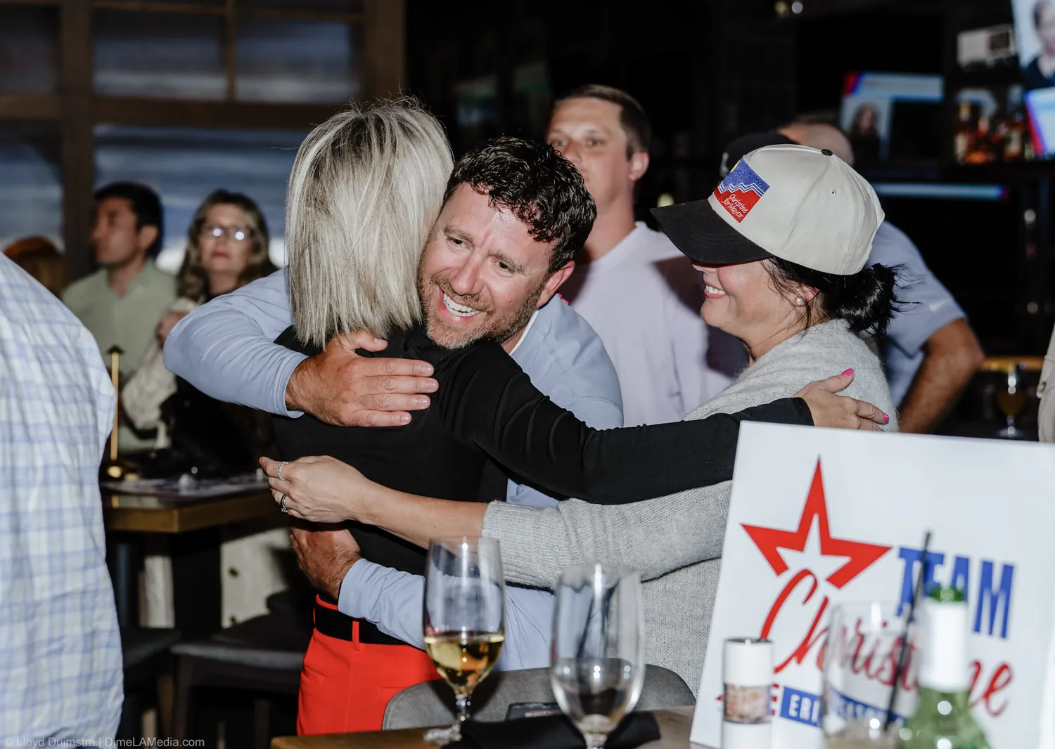 An embrace beside a Team Christine sign at the election night celebration