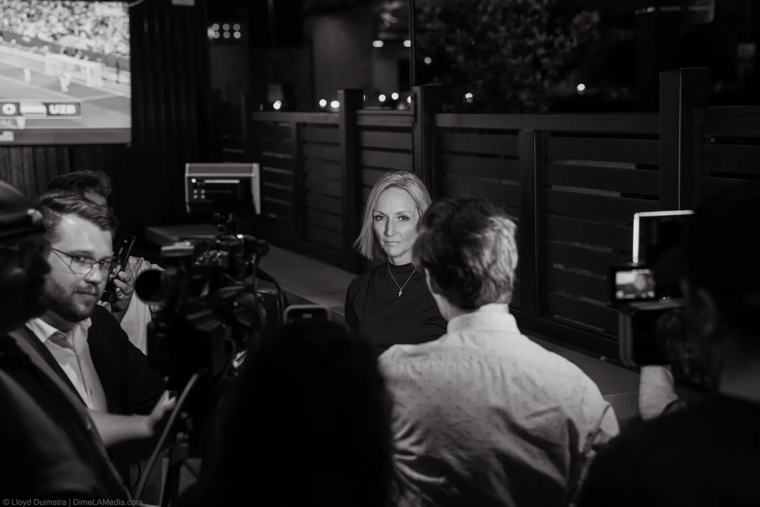 Black and white frame of Christine Erickson giving an on-camera interview after winning on election night