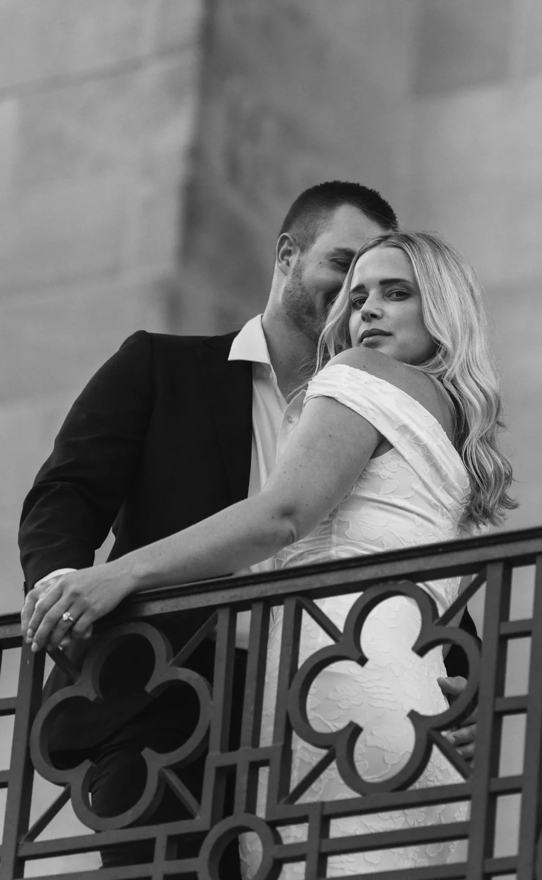 Black and white kiss on the forehead behind an iron quatrefoil railing, Sioux Falls SD
