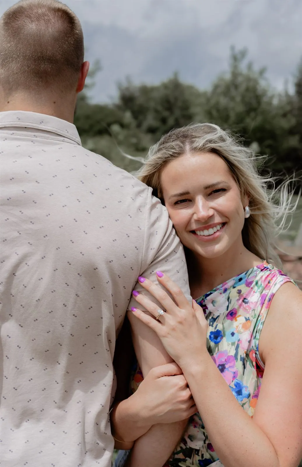 Close portrait of a newly engaged woman resting on her fiance, ring on display