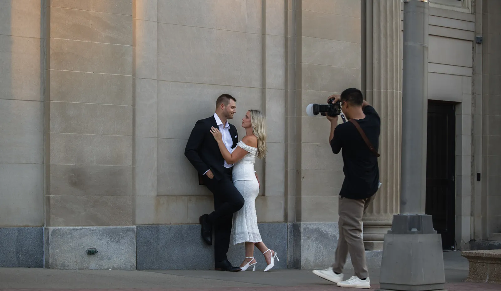 Photographer Lloyd D. photographing an engagement session against the limestone in downtown Sioux Falls, SD