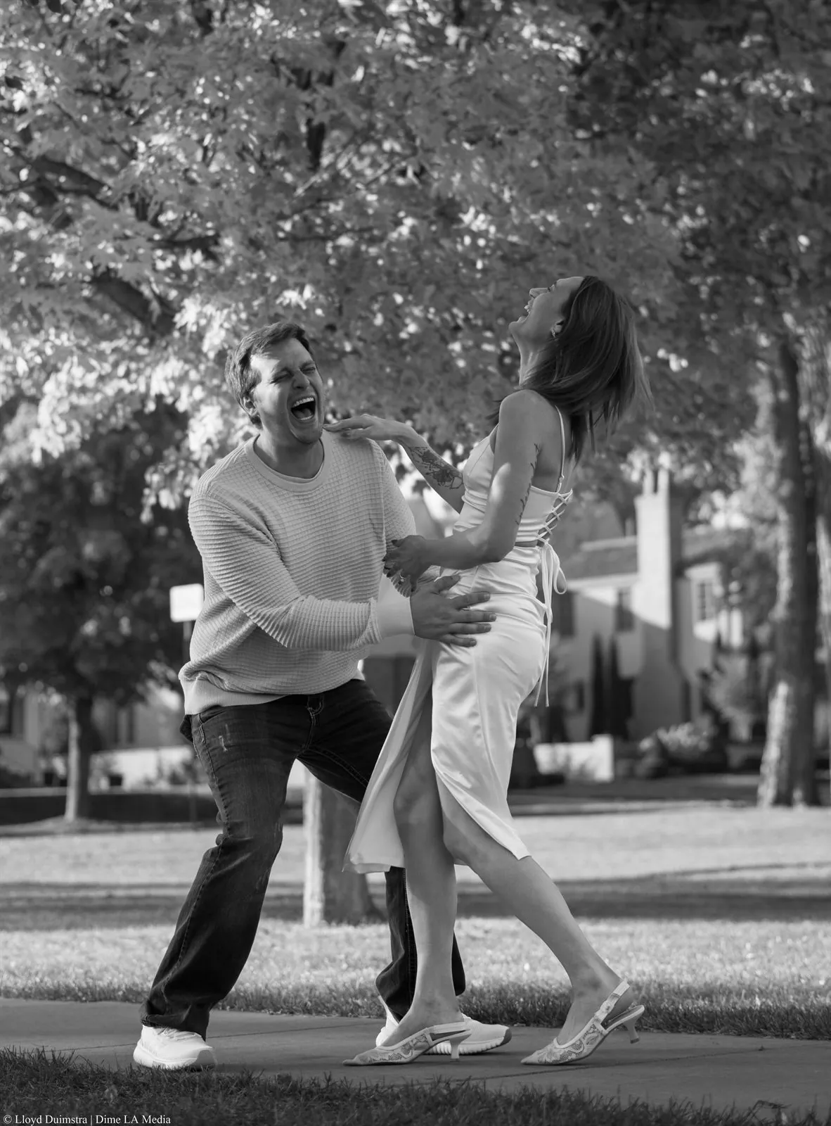 Black and white candid of an engaged couple laughing together