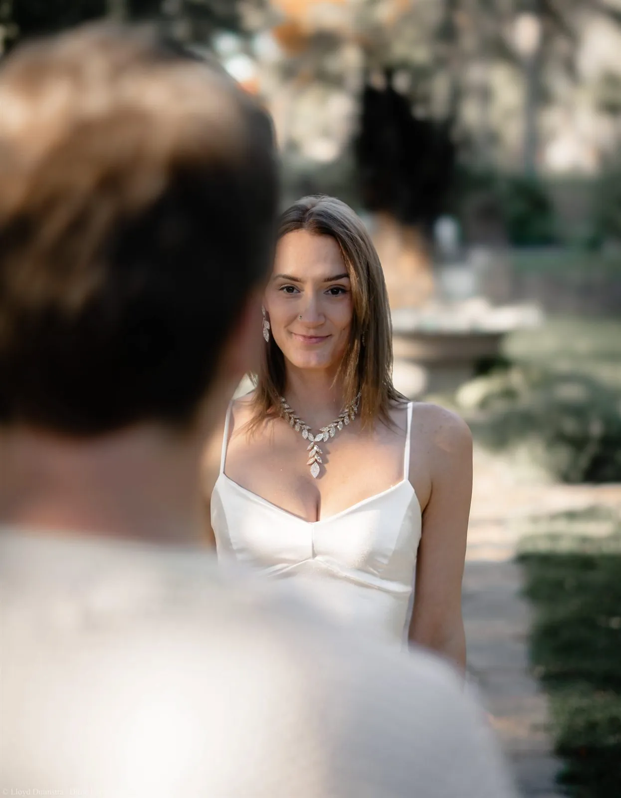 Portrait of a woman in a white dress and statement necklace at golden hour