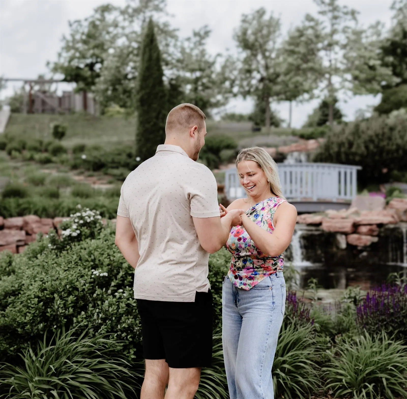 Couple holding hands and looking at the engagement ring together
