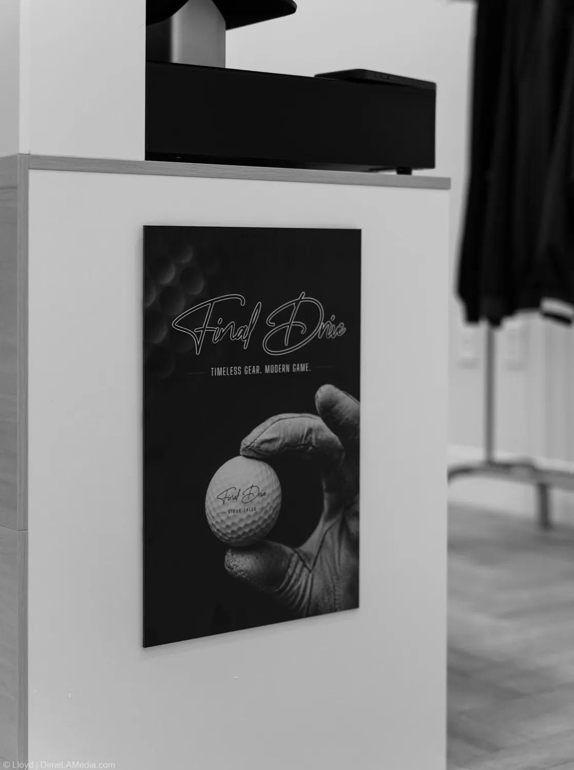 Black and white frame of golf artwork beside the fitting area at Final Drive