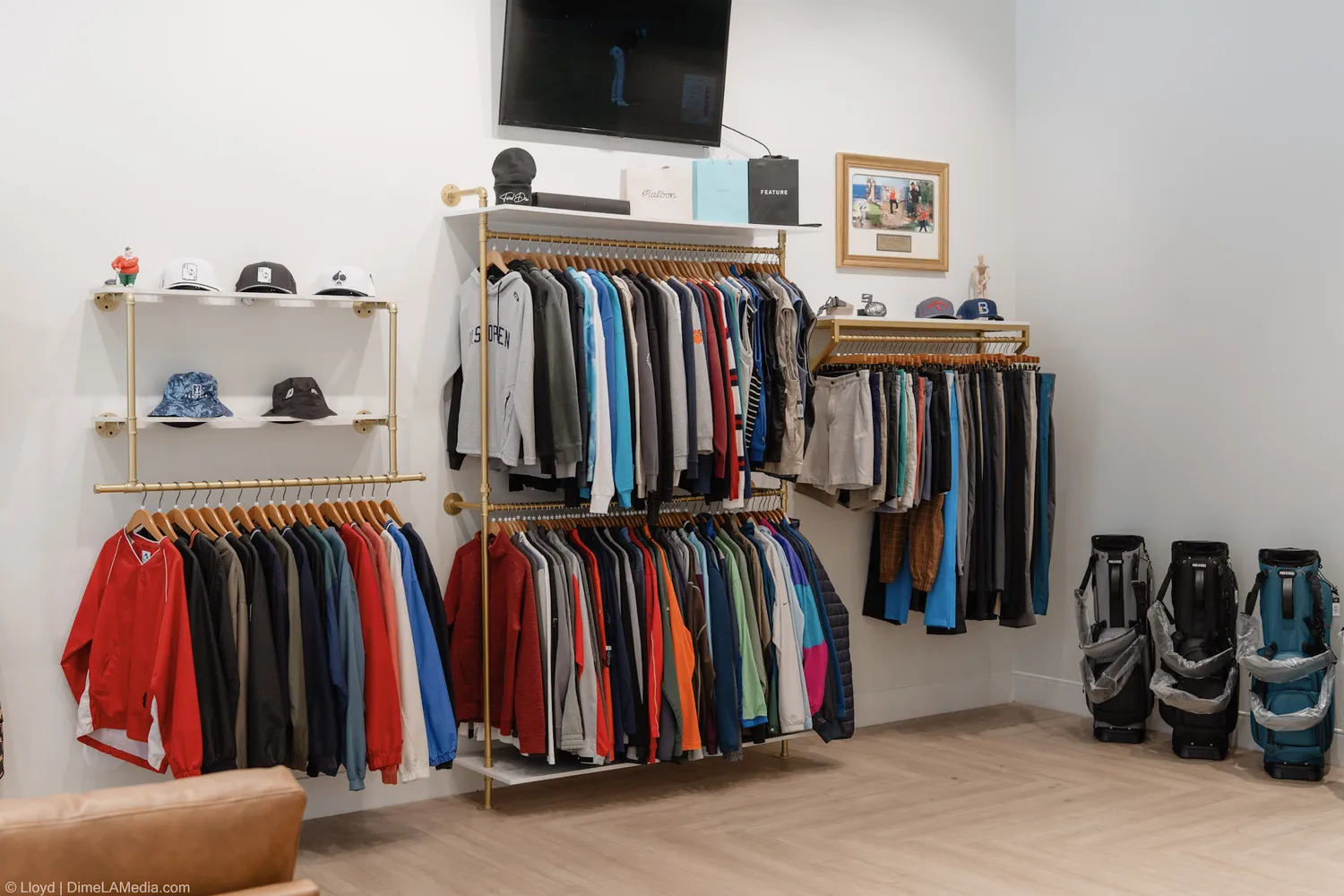 Racks of golf polos and jackets below wall-mounted golf bags at Final Drive