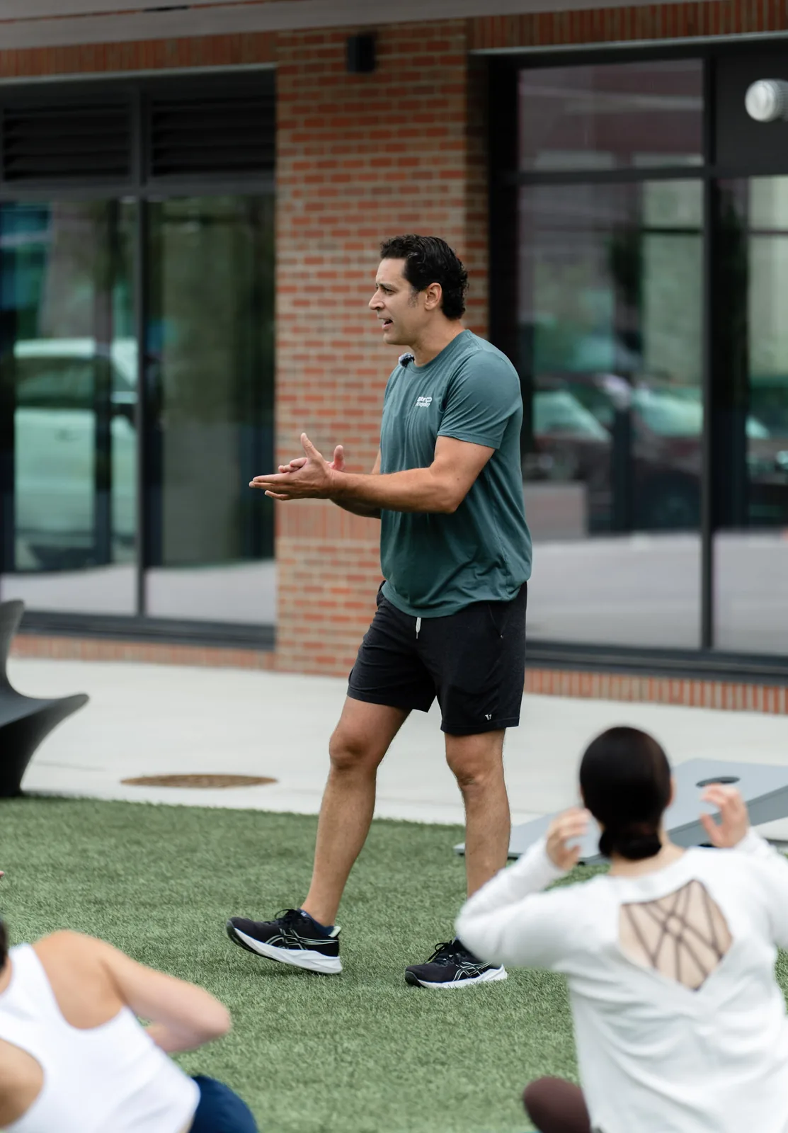 A Sisu coach talking the class through the next round of the outdoor Kinstretch session on the lawn at Cherapa Place, Sioux Falls SD
