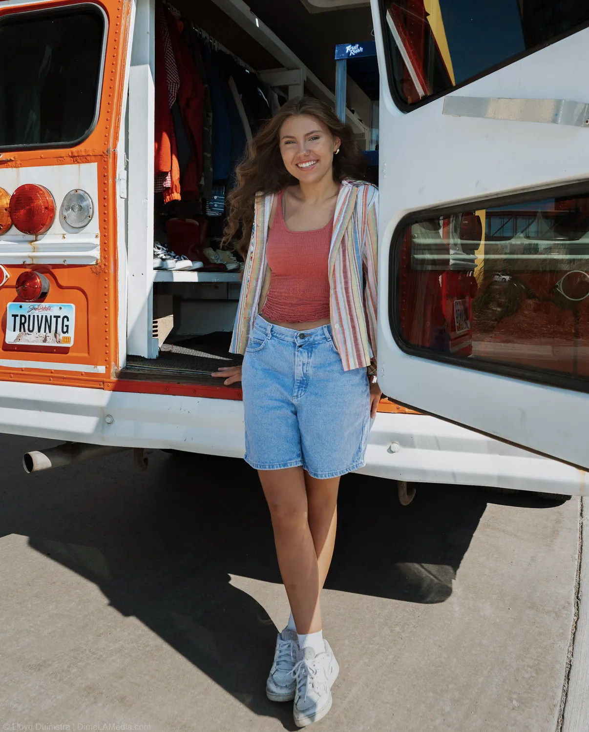 Maddie Theisen stands at the back of the True Vintage bus with the doors swung open