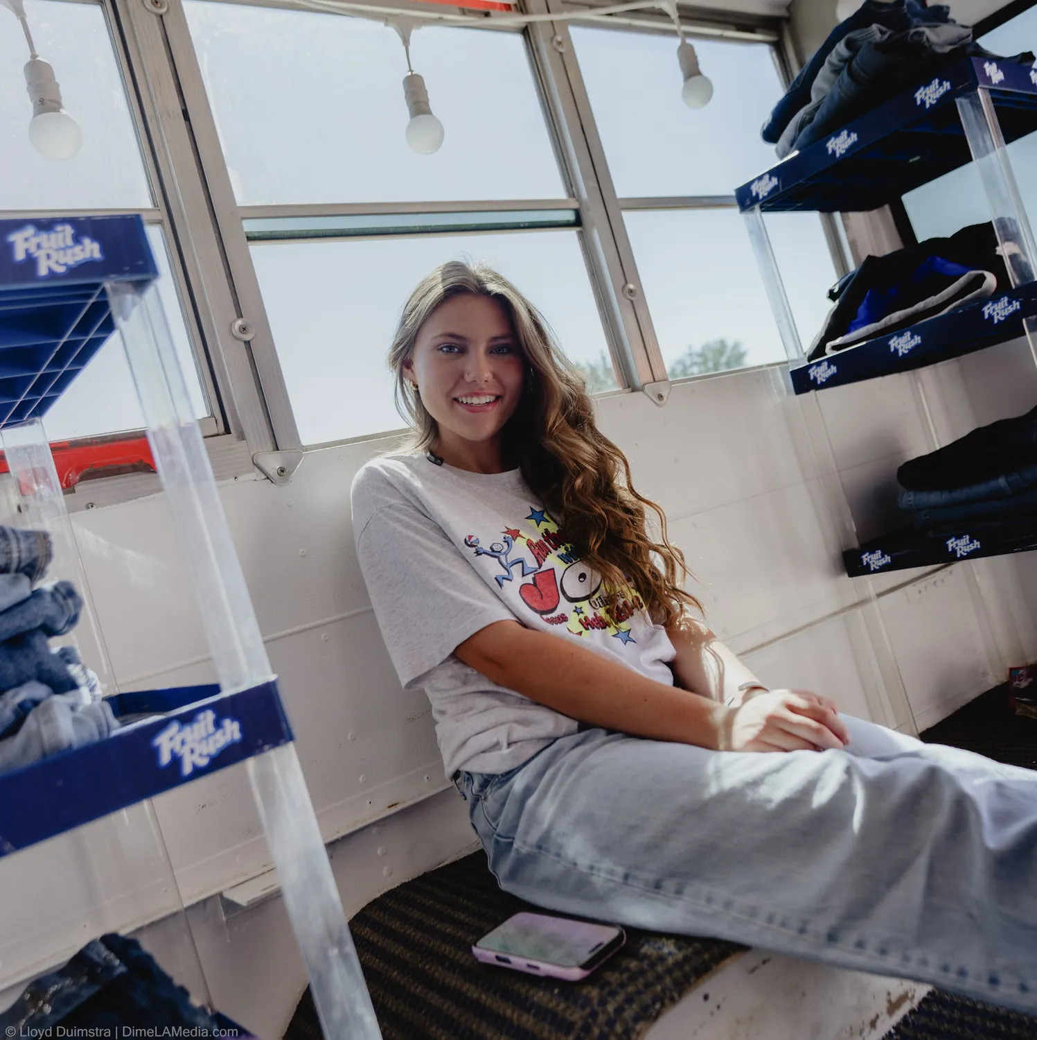 Maddie Theisen smiles in window light inside the True Vintage bus