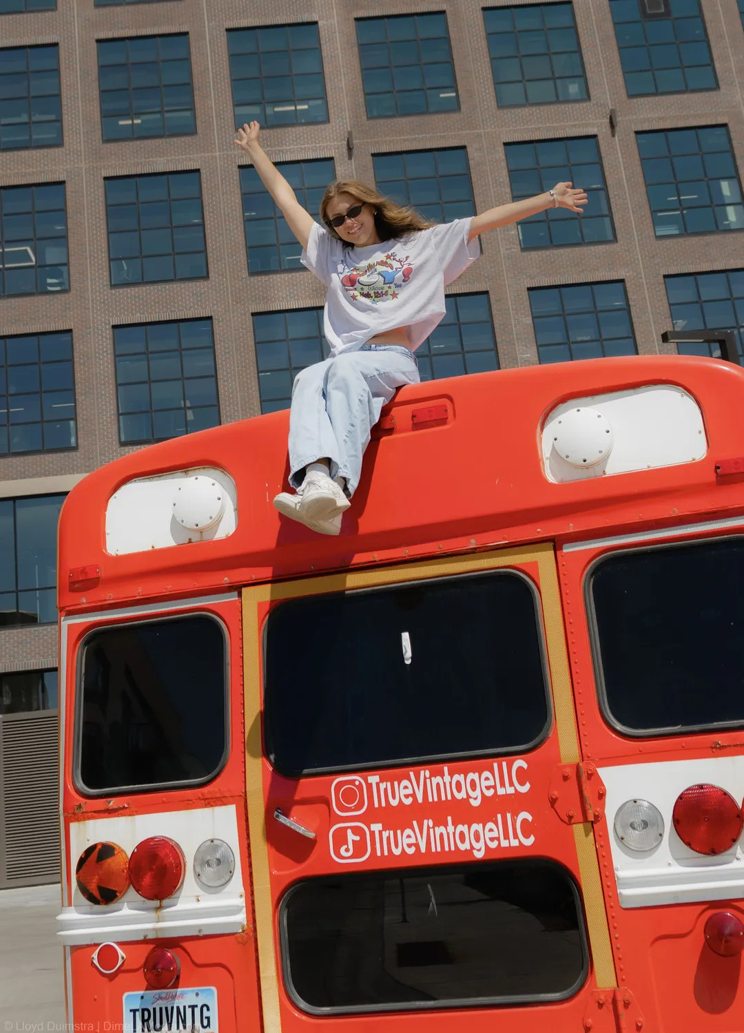 Maddie Theisen raises her arms on the roof of the True Vintage bus in downtown Sioux Falls