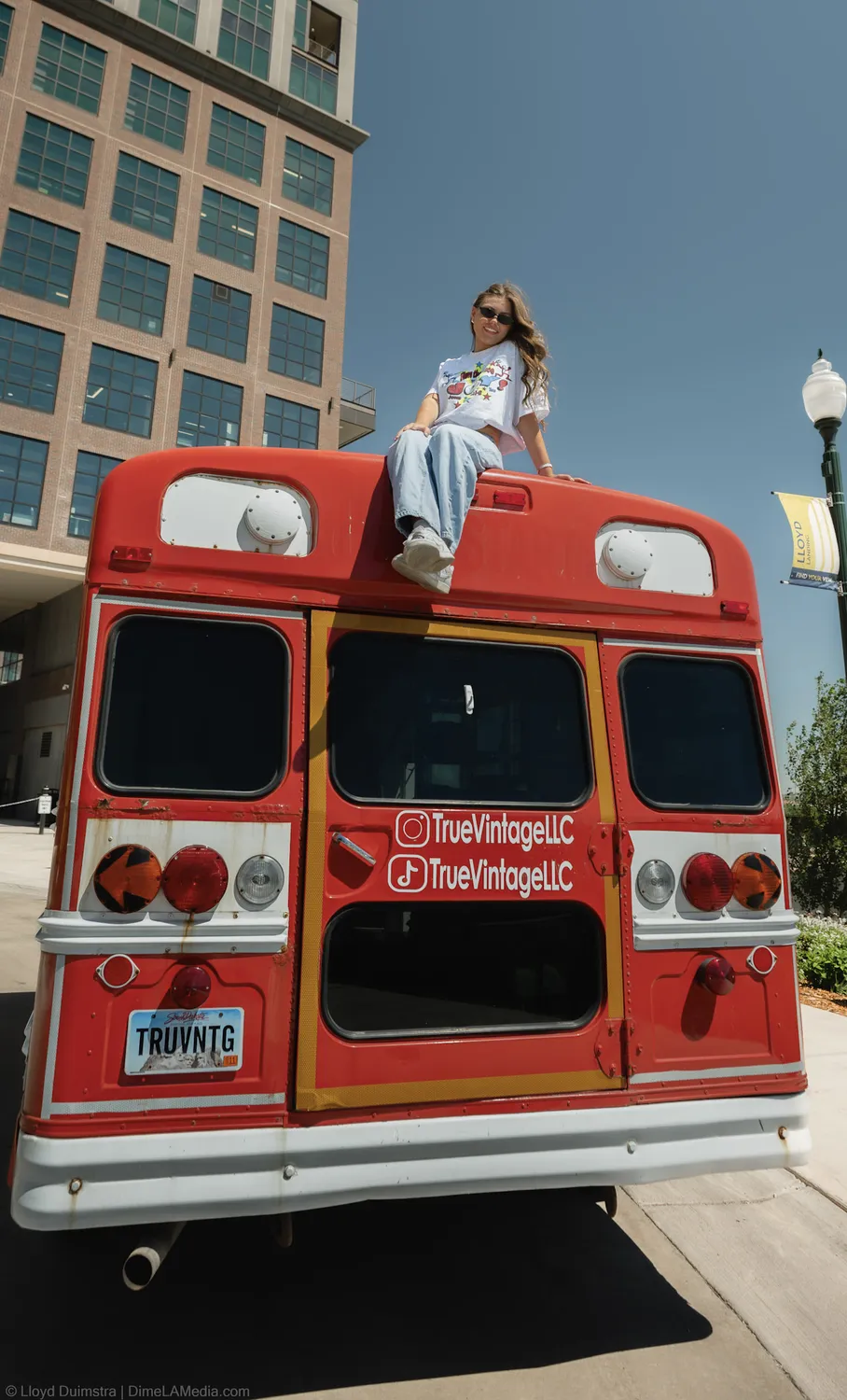 The back of the True Vintage bus with its Instagram and Facebook handles painted on, Maddie seated on the roof