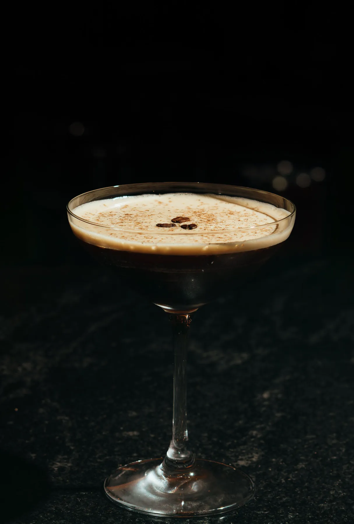 Espresso martini cocktail on a dark bar top
