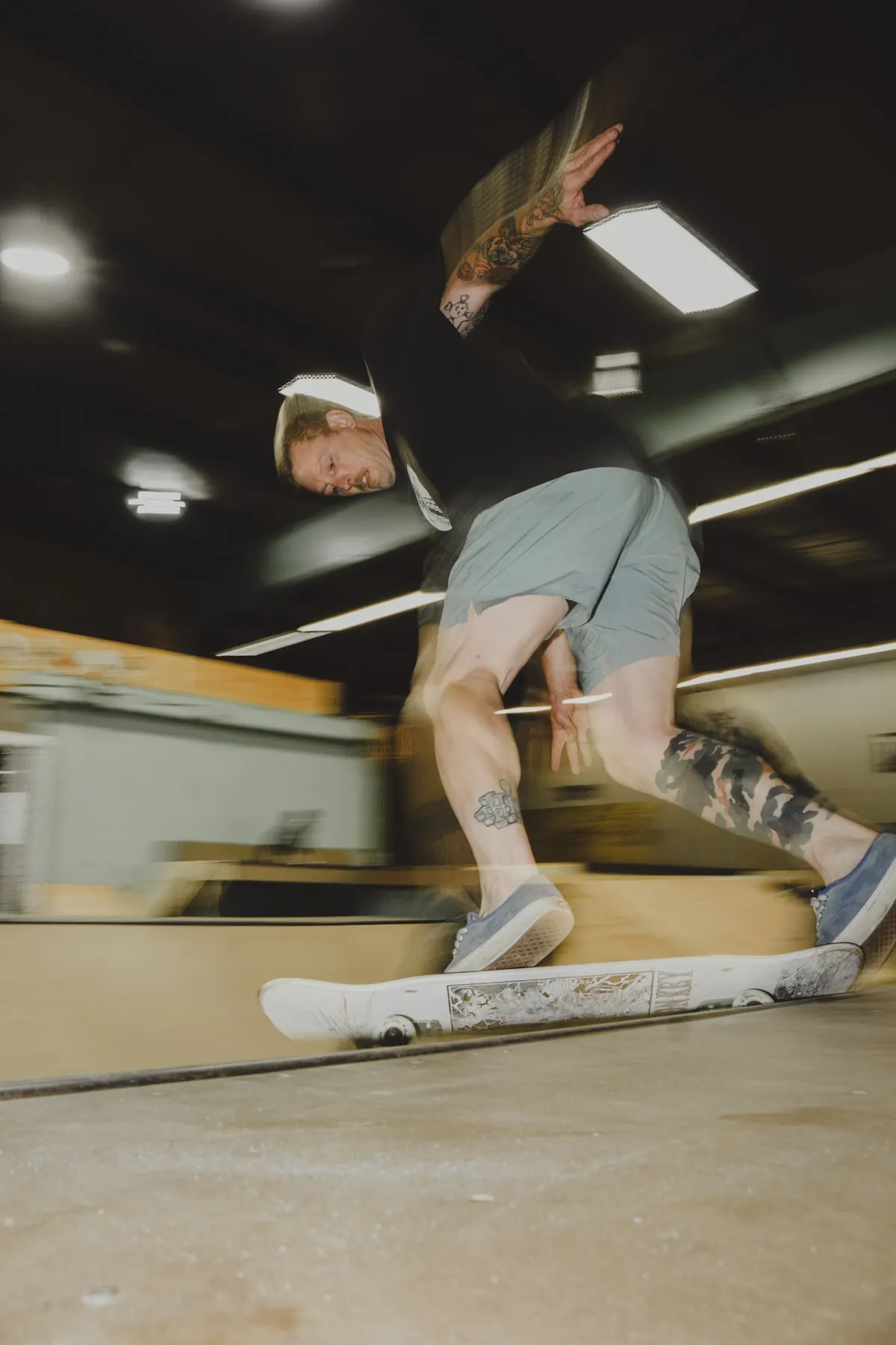 Fisheye skate photo mid-trick on the indoor ramp