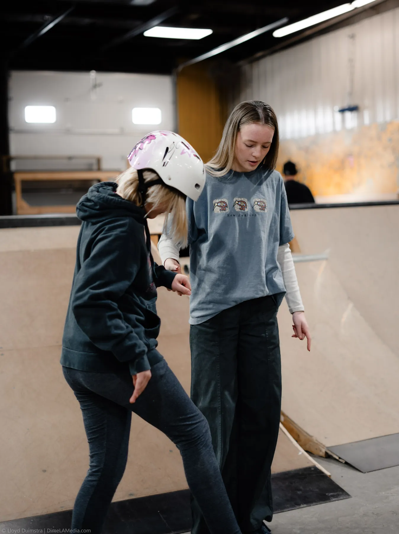 Helmeted beginner finding her balance at a skate clinic