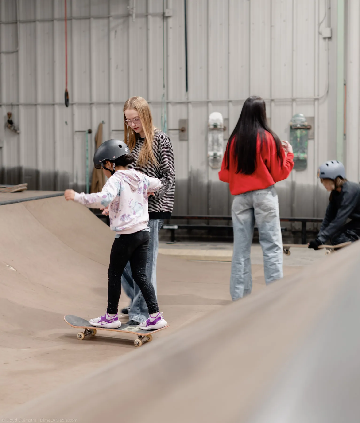 Kids learning to skate at an indoor skateboarding clinic