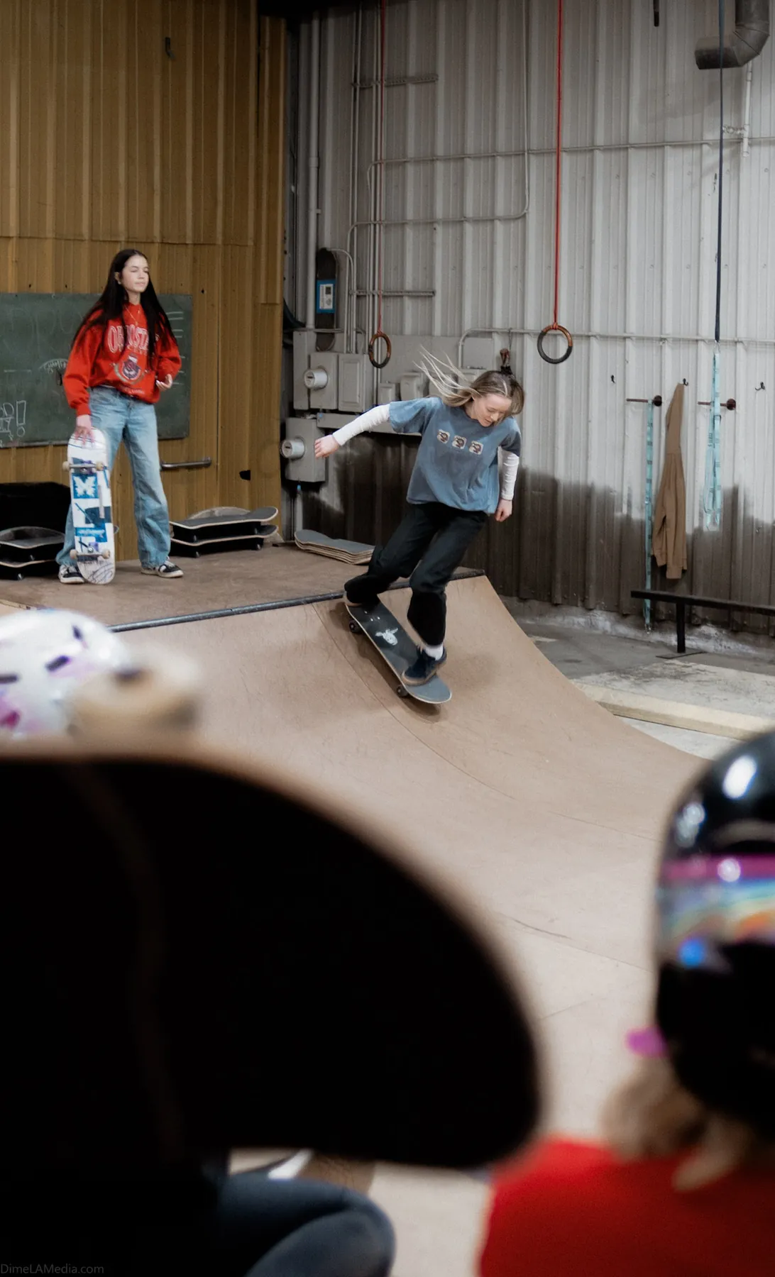 Young skater dropping in while friends watch