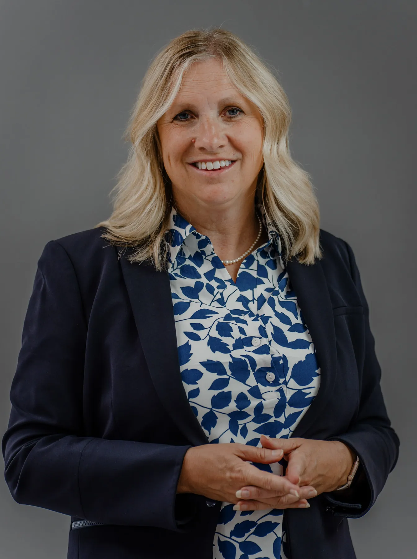 Business headshot of a woman in a navy blazer, mobile studio setup at a Sioux Falls office