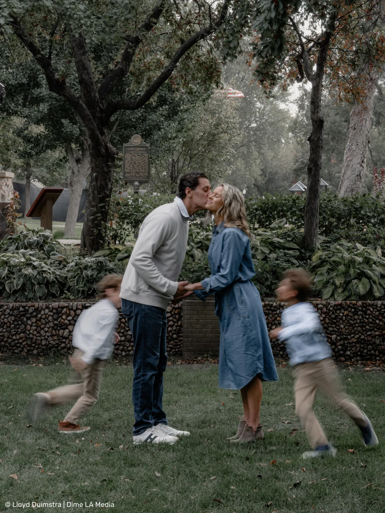 Creative family portrait with kids in motion blur while parents kiss