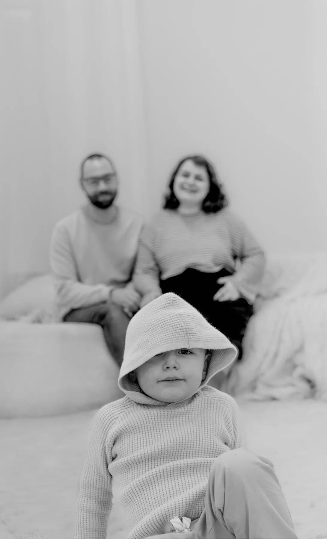 Toddler peeking from a hooded blanket, studio family session