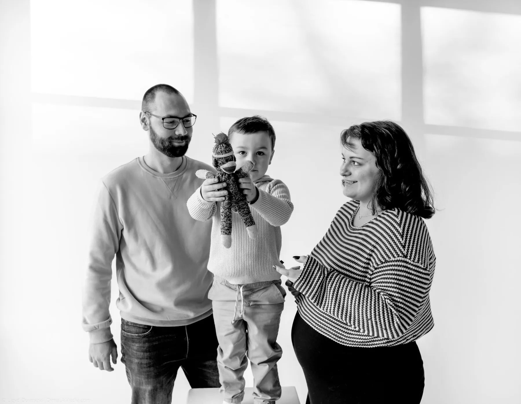 Black and white family maternity portrait lifting the toddler high