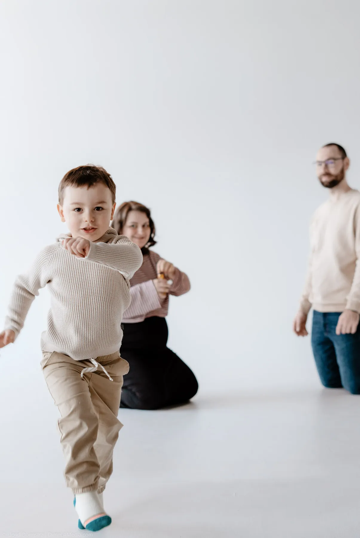 Toddler mid-sprint across the studio during a maternity session
