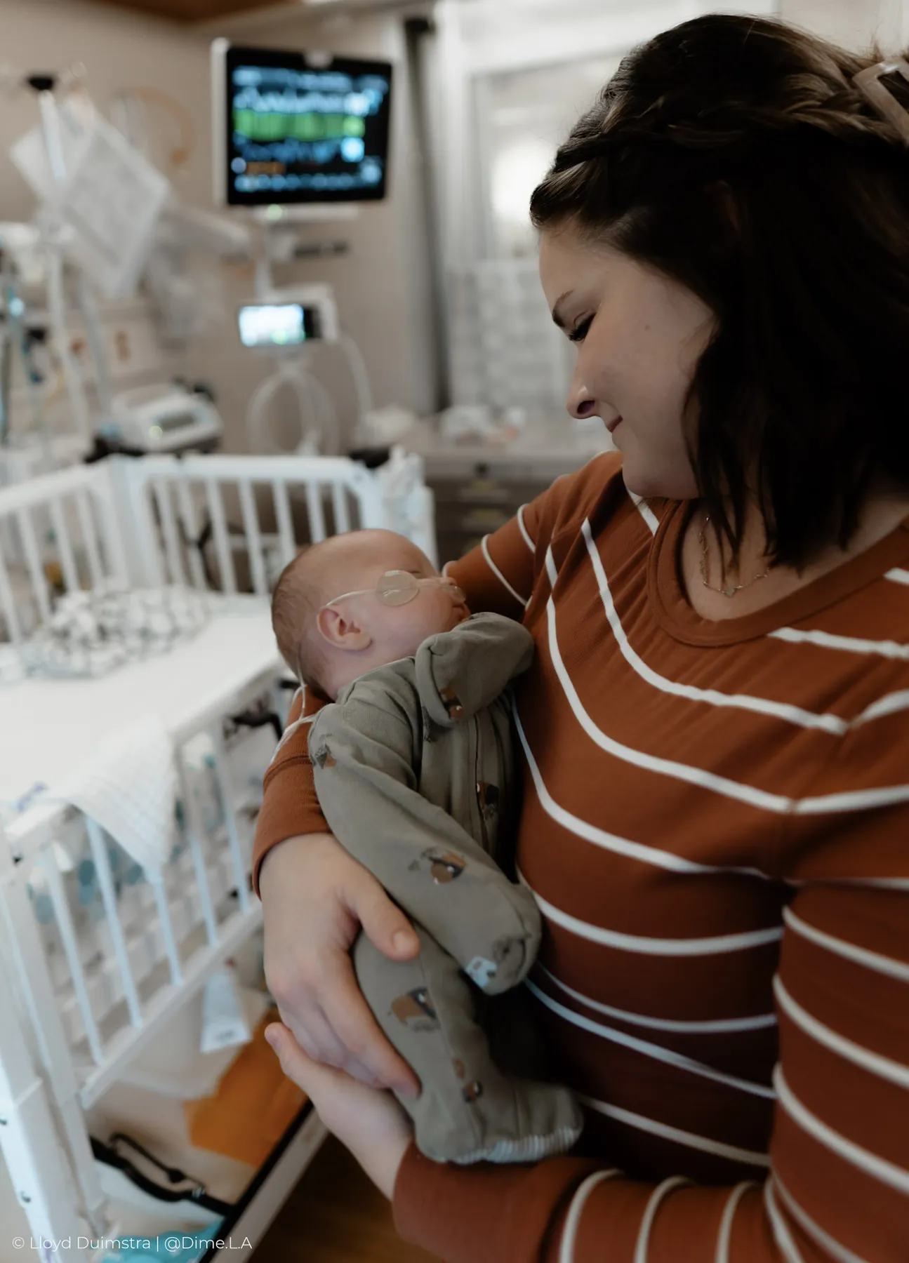 Mom holding her son beside the NICU monitors
