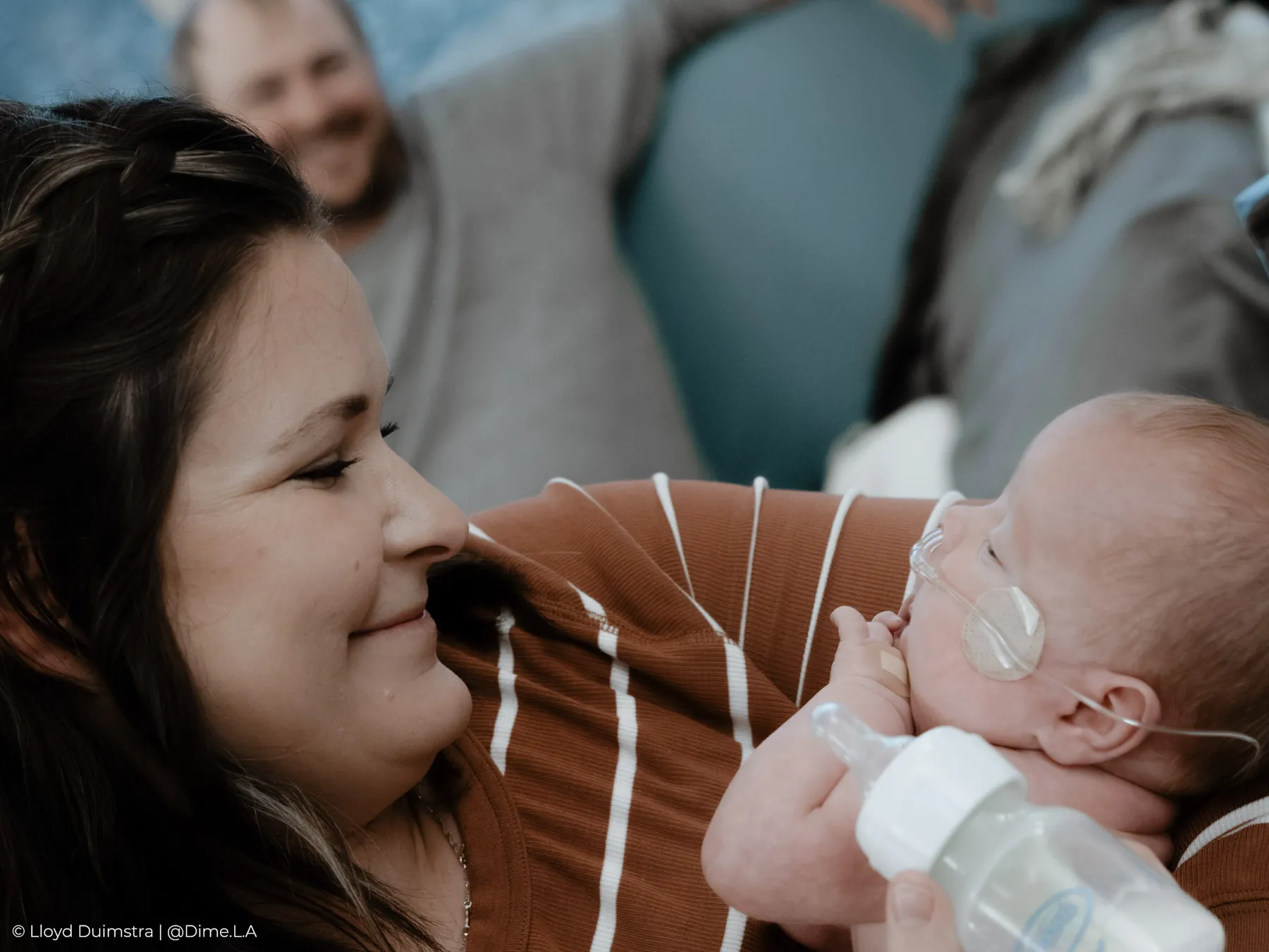 Mom smiling at her son during a NICU bottle feeding