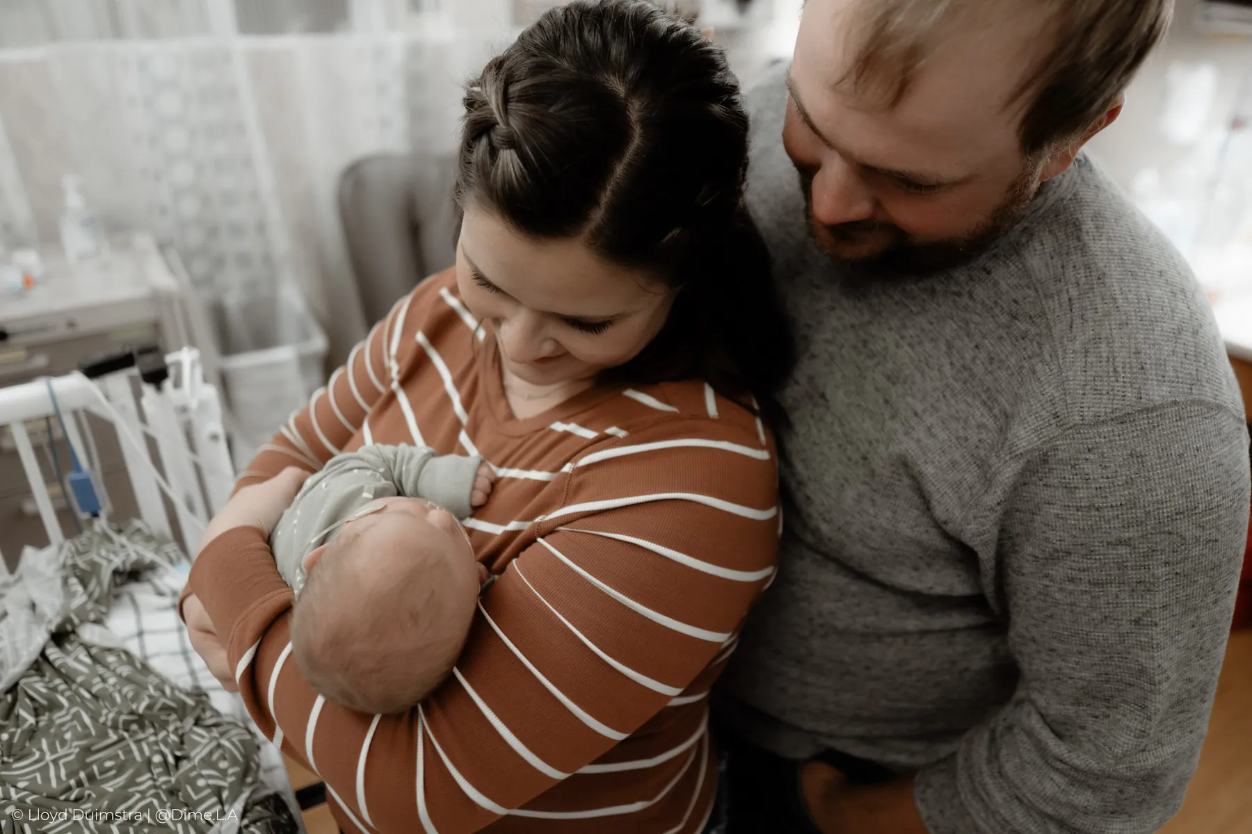 Parents huddled around their newborn in the NICU