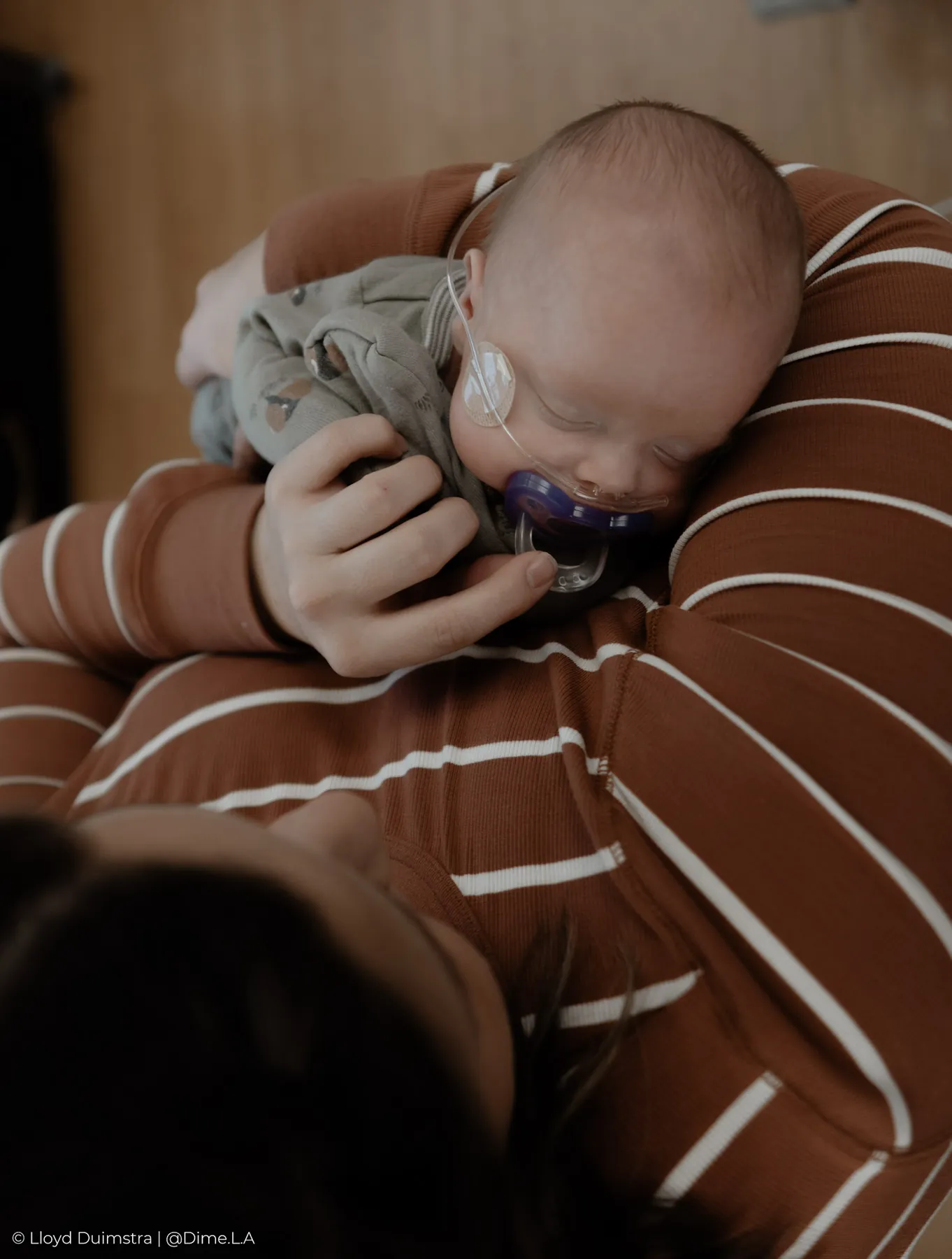 Newborn snuggled against mom’s shoulder
