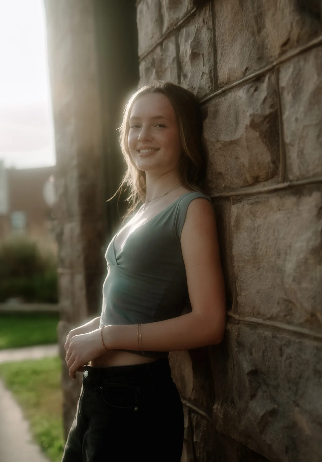Senior portrait backlit against stone at golden hour, Sioux Falls SD