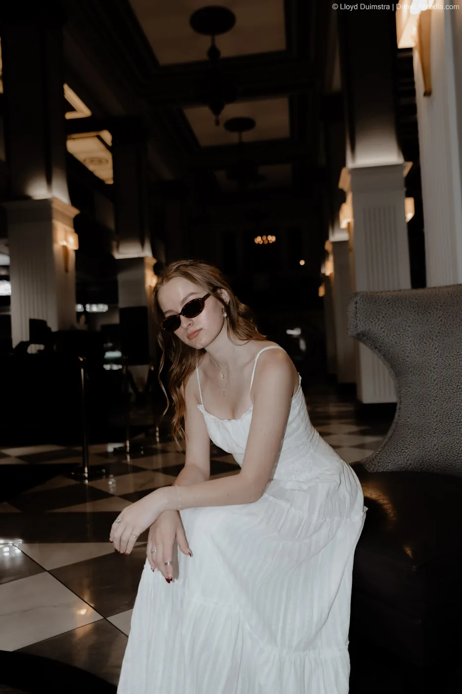 Syd Patzwald senior portrait leaning forward in a historic hotel lobby