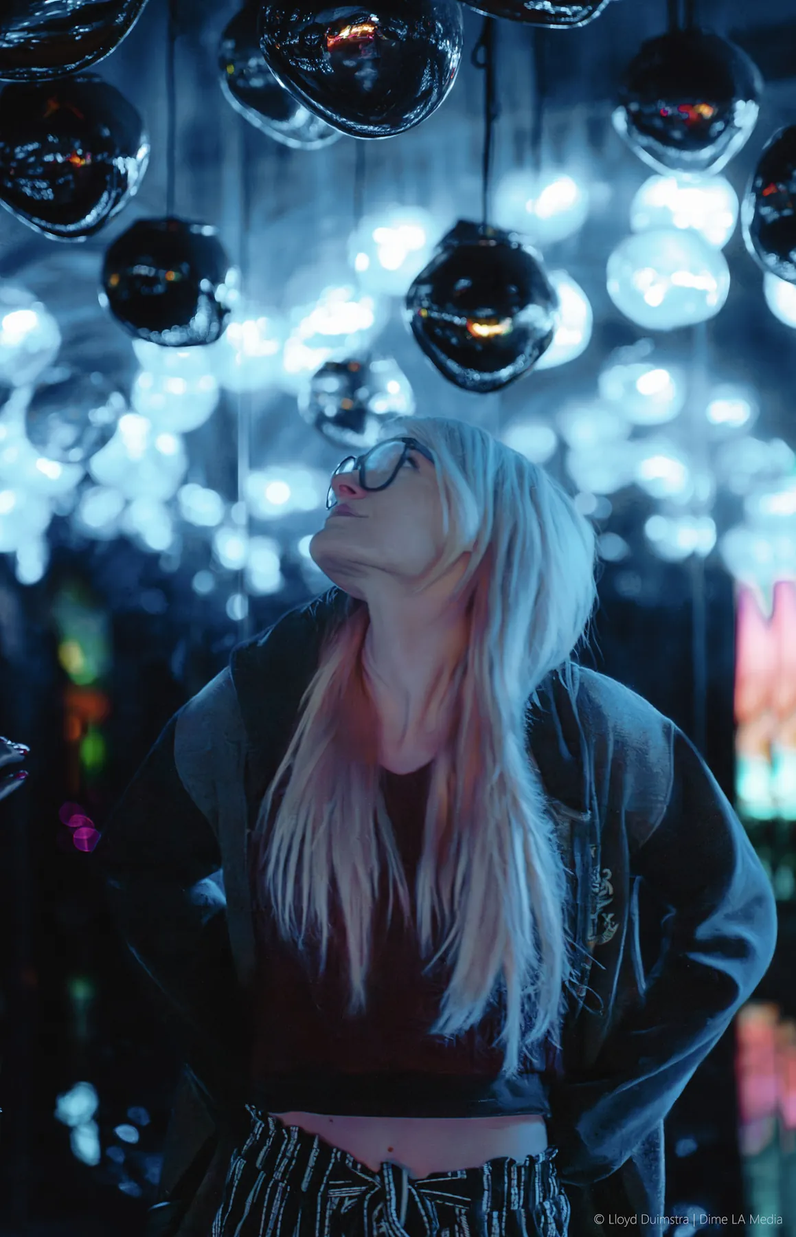 Editorial portrait under a glass light installation at night
