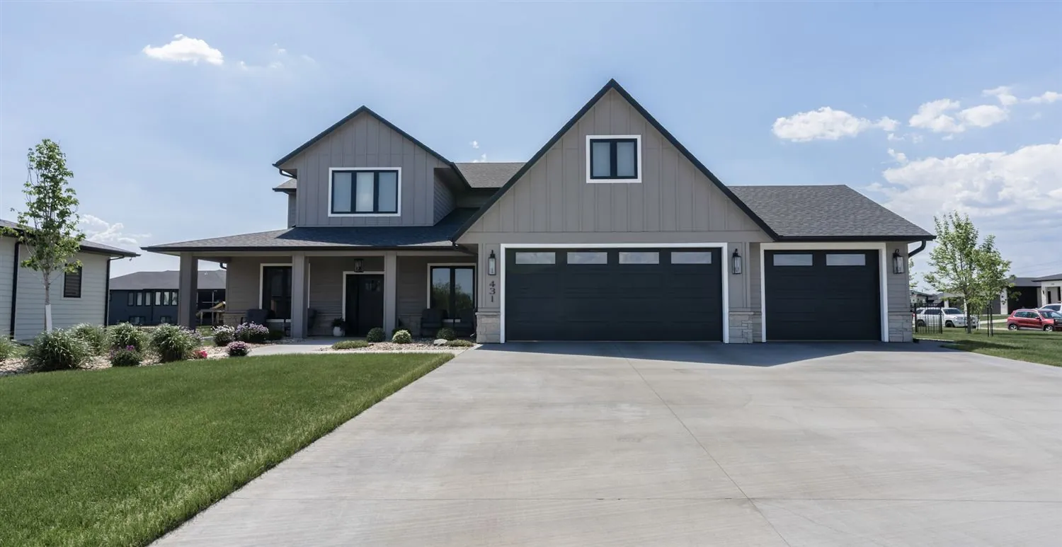 Front exterior of a modern two-story home with a three-car garage, real estate photography in Sioux Falls South Dakota