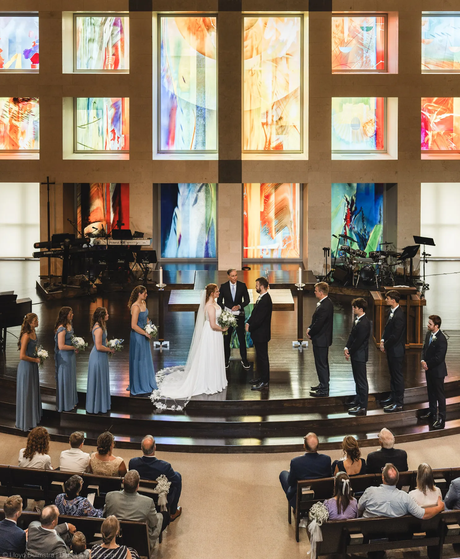 Wide view of the ceremony against stained glass