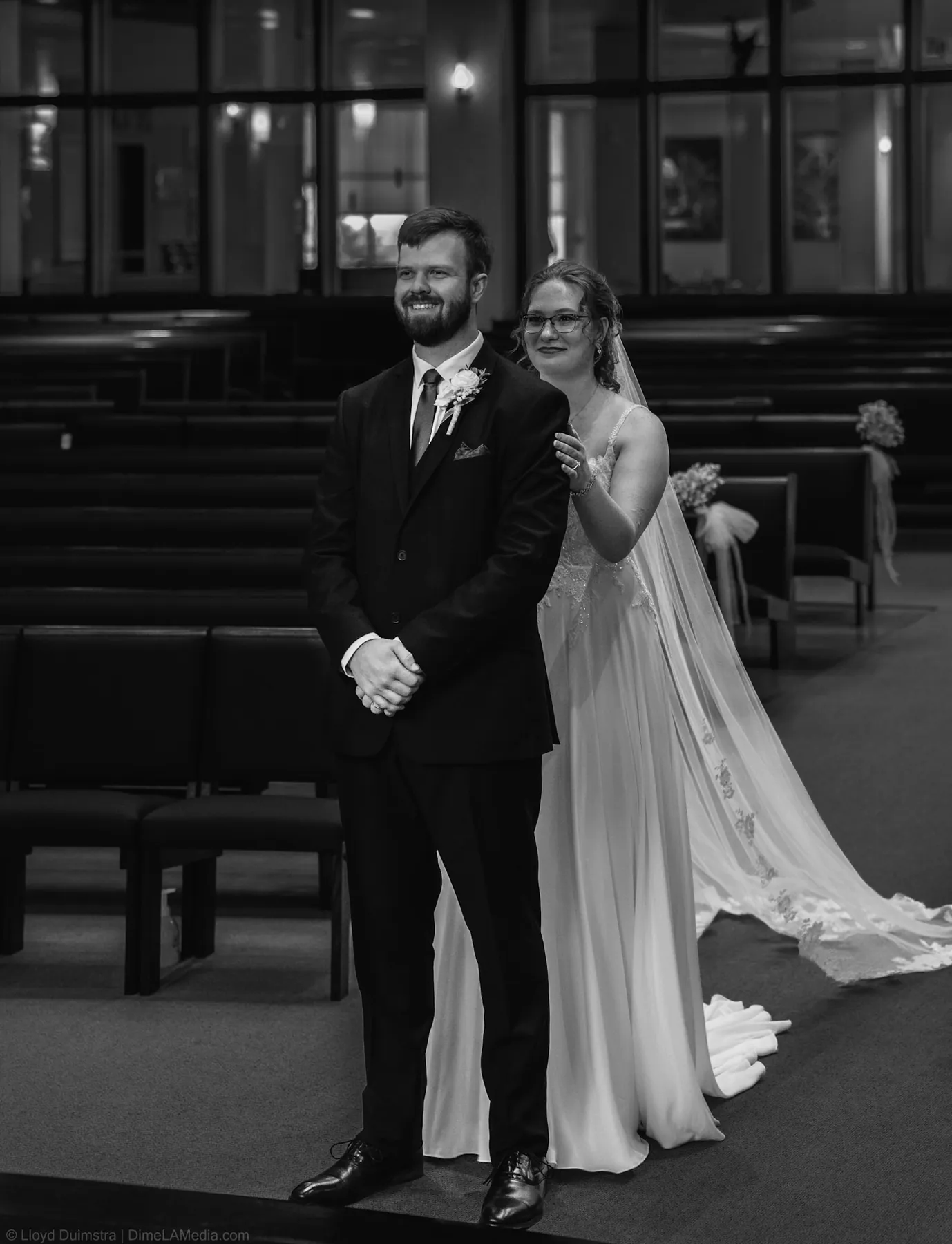 Bride and groom walking together down the aisle in black and white